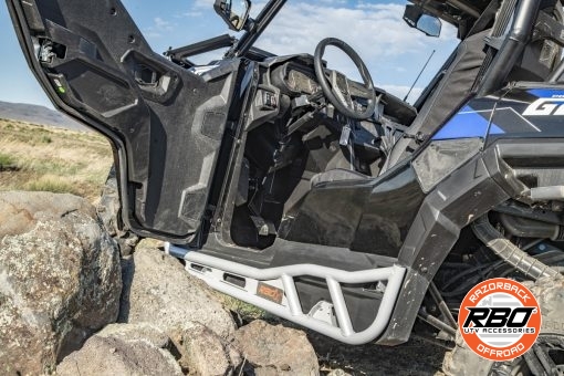 A utv with door open is parked on the side of a dirt field