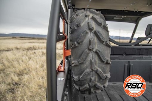A closeup of a spare tire mounted to a bobcat spare tire mount in bed of utv