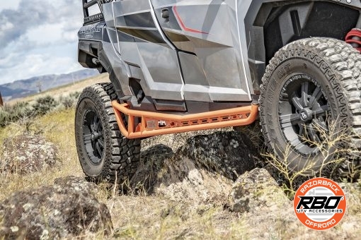 A closeup of a utv parked on the side of a dirt field