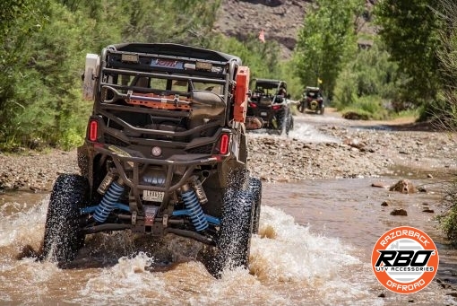 UTVs driving through a riverbed