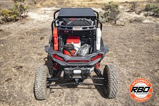 UTV parked on the side of a dirt field filled with gear