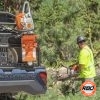 Man using a chainsaw next to an ATV