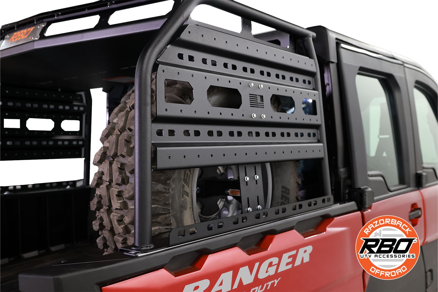 Razorback Offroad Spare Tire Mount holding spare tire securely in cargo area of Polaris Ranger XD 1500.