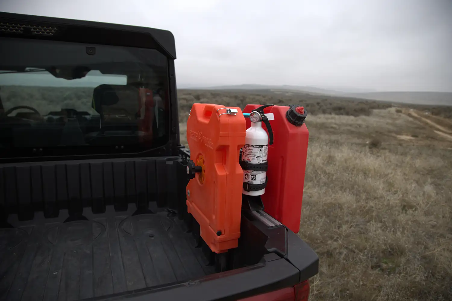 Voile Straps nylon buckle securing fuel and water cans in a truck bed for overland gear tie-down