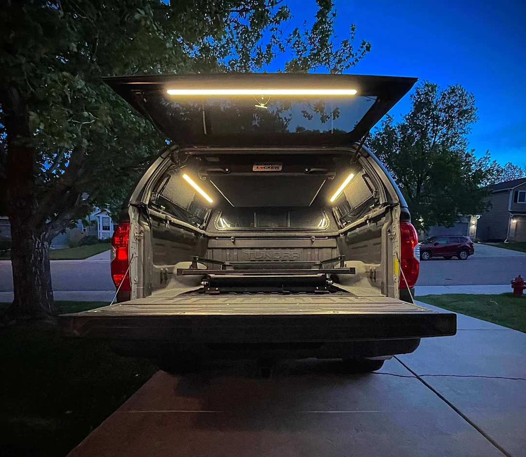 kingpin-v-series-40-rotating-led-light-bar-truck-bed-camper Kingpin V-Series 40" Rotating LED Light Bar illuminating a truck bed and camper shell at night.